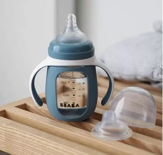 A blue and white non-toxic baby bottle made with a glass body and silicon teat. It features garge side handles making this bottle easy to grip. Produced by BÉABA